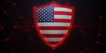 Digital shield with US flag, red lines indicating cyber threat, binary code background